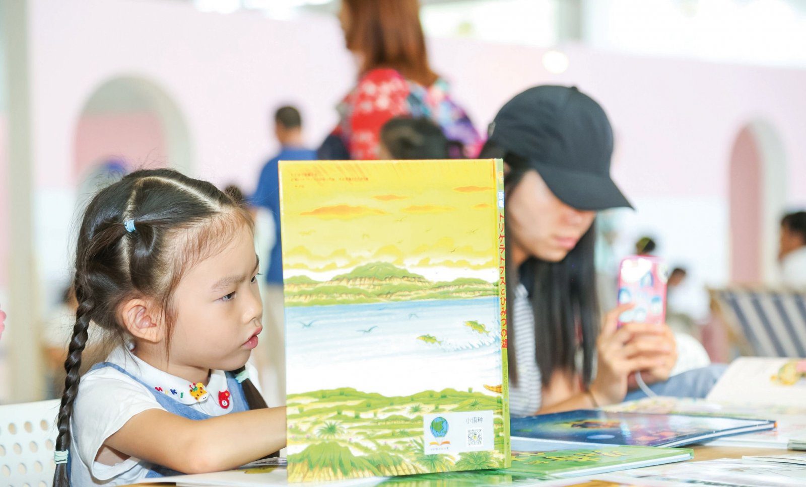 Gucken, lesen, lernen: In China, dem größten Kinderbuchmarkt der Welt, ist es völlig normal, Kinder zu großen buchrelevanten Veranstaltungen mitzunehmen. Während der Pekinger Buchmesse gibt es nicht nur auf dem Messegelände reichlich Gelegenheit, in neuen Büchern zu blättern (Foto). Auch in der Stadt werden Eltern und Nachwuchs an vielen Eventstandorten hofiert. (Foto: Beijing Book Fair)