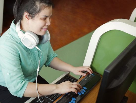 Passende Hard- und Software ist gefragt: Eine blinde Frau nutzt am Computer ein Braille-Display (Foto: 123RF.com/chfonk)